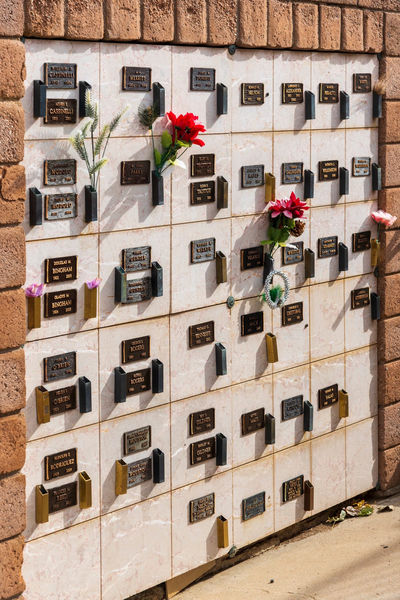 A columbarium wall of niches with flowers