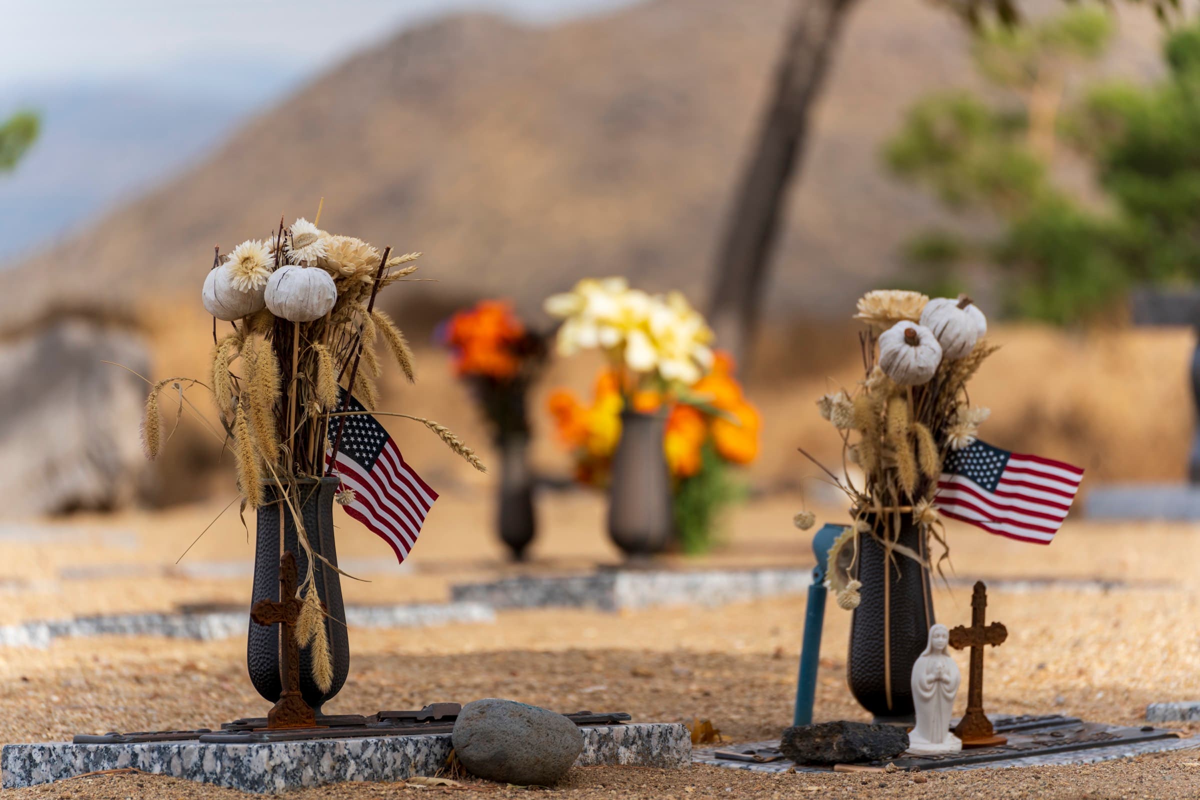 American flags and flowers at a graveside