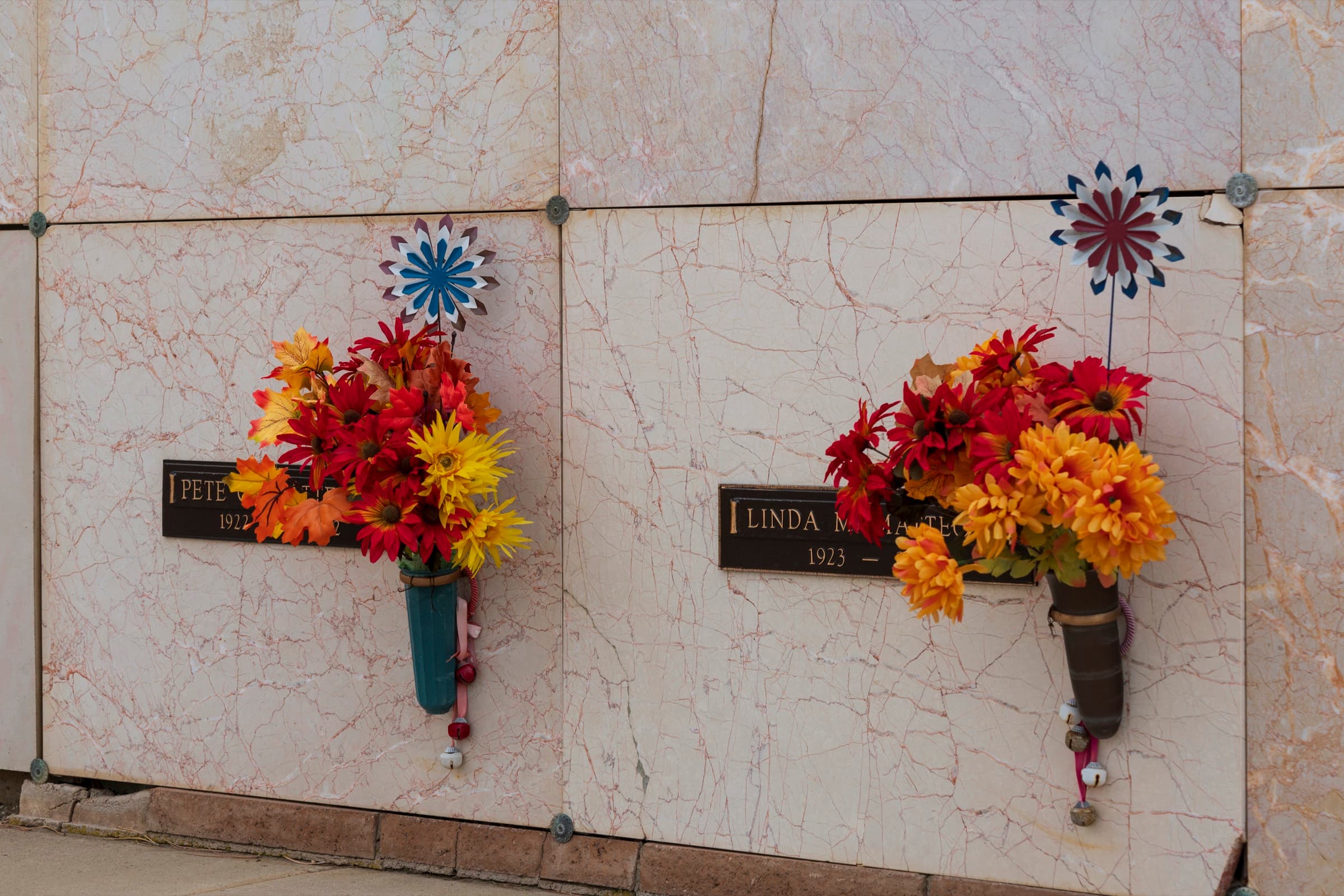 Red and orange flowers on a marble niche wall