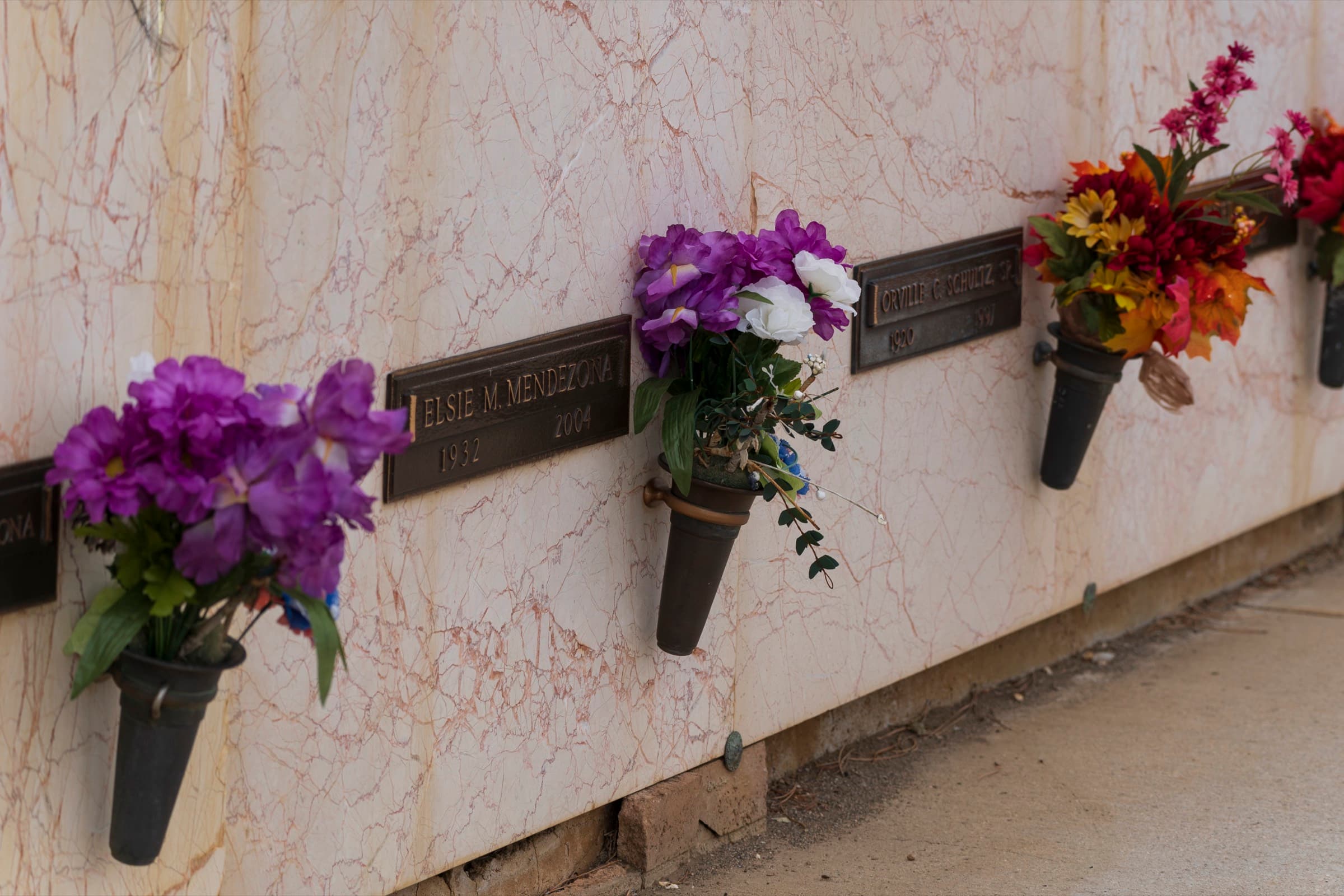 Fresh flowers along a marble niche wall