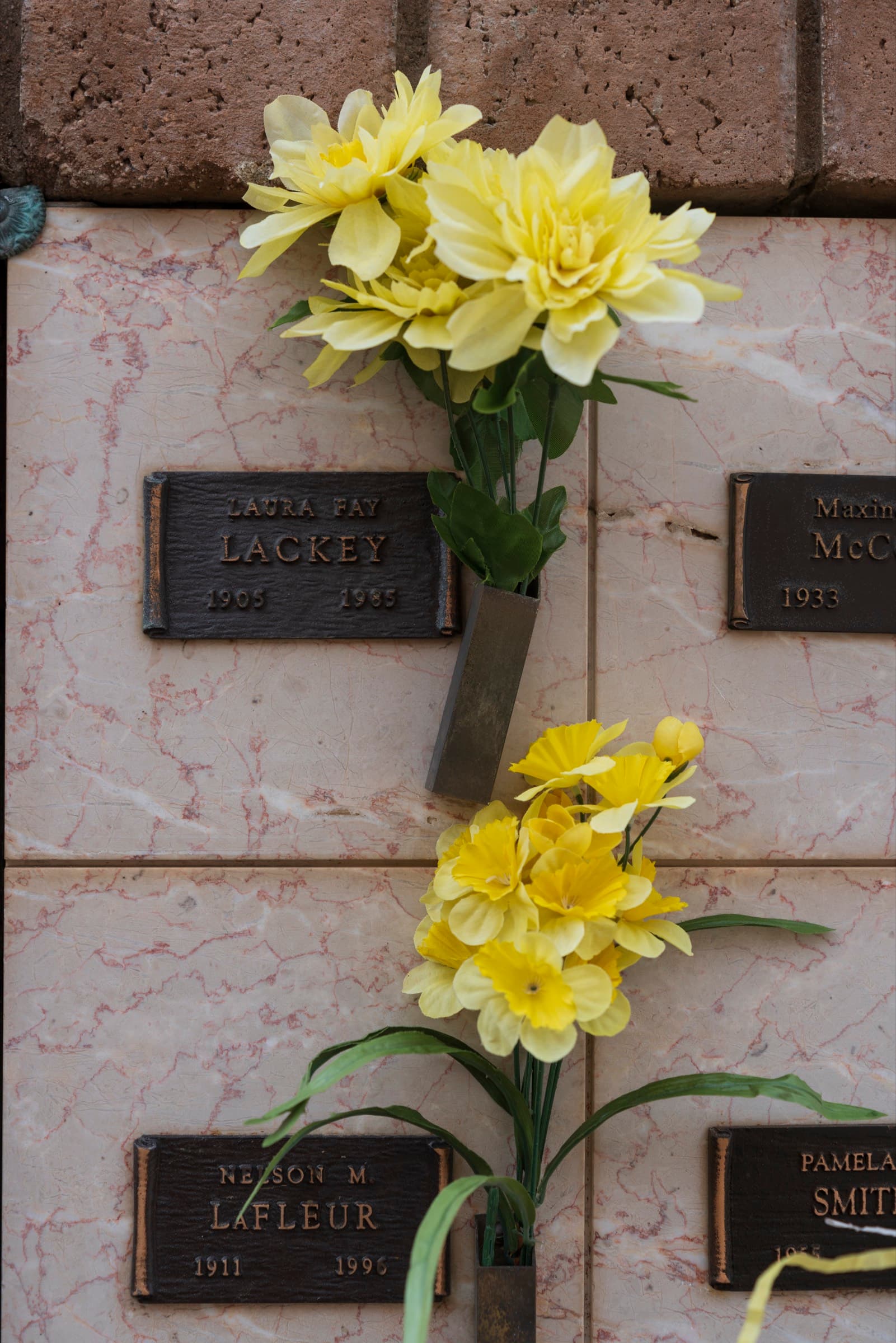Yellow flowers on a marble niche wall